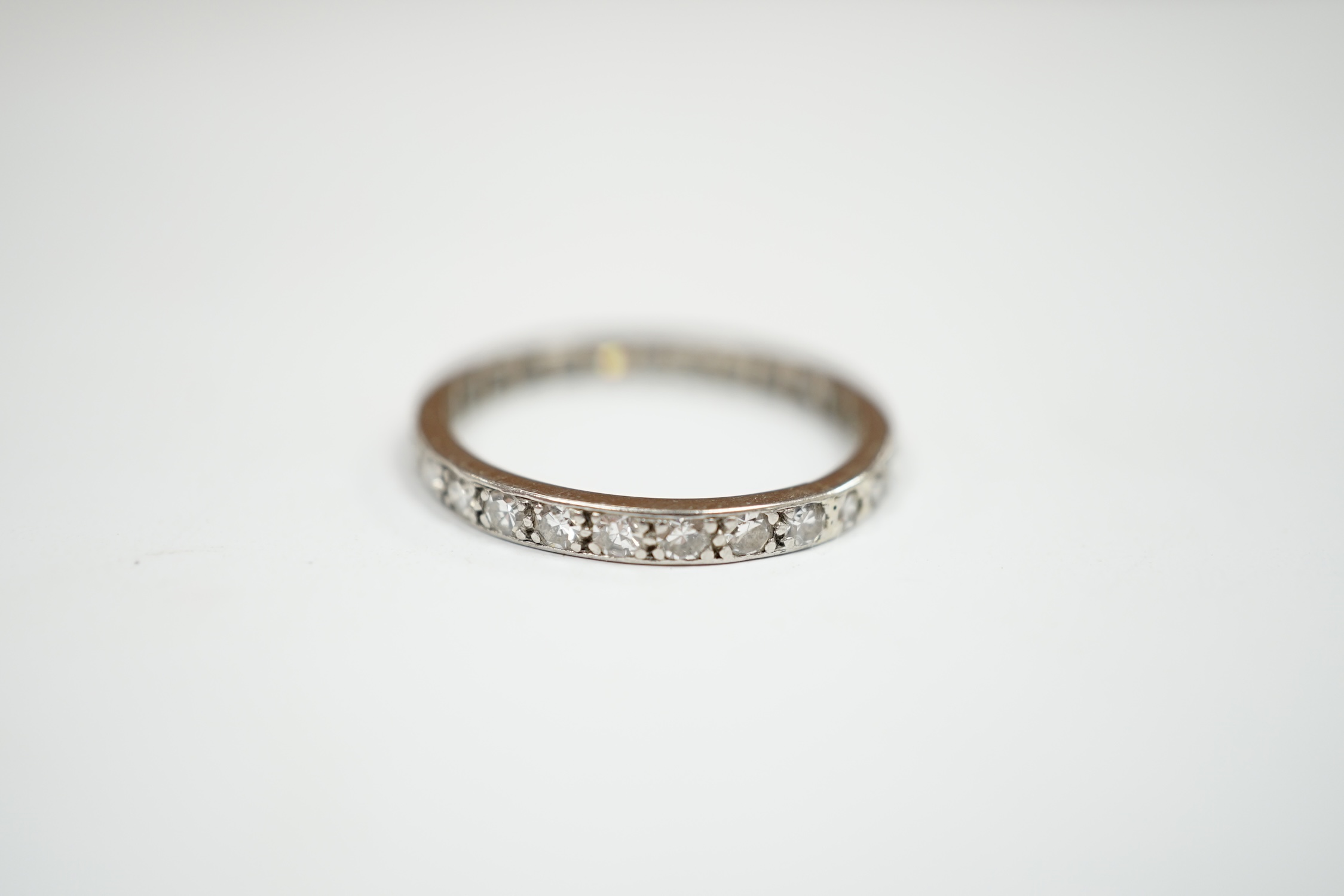 A white metal and diamond set full eternity ring, size P, gross weight 2.6 grams. Condition - fair
